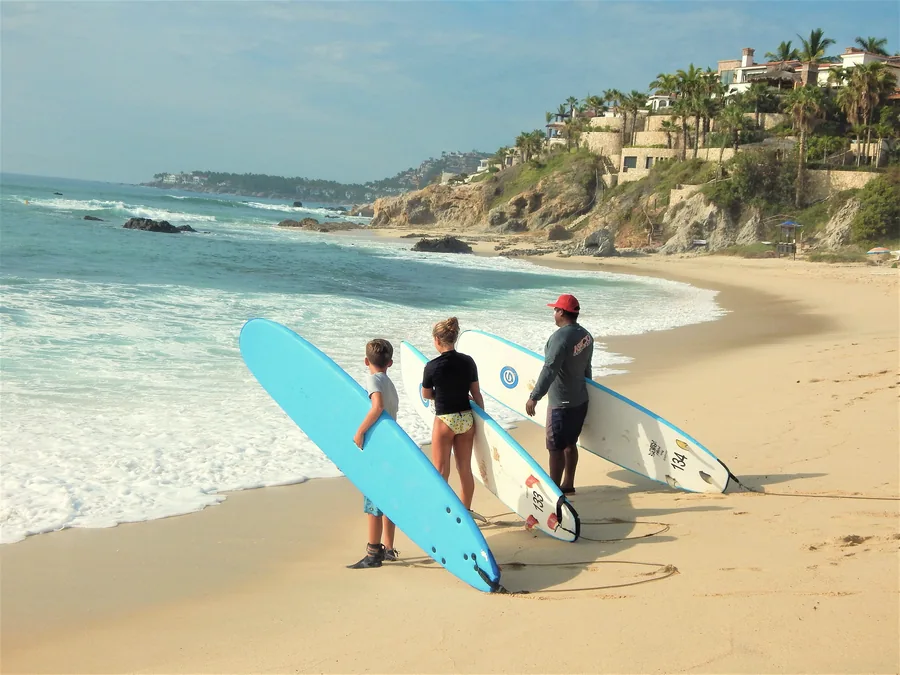 Family with three surfboards watching the waves