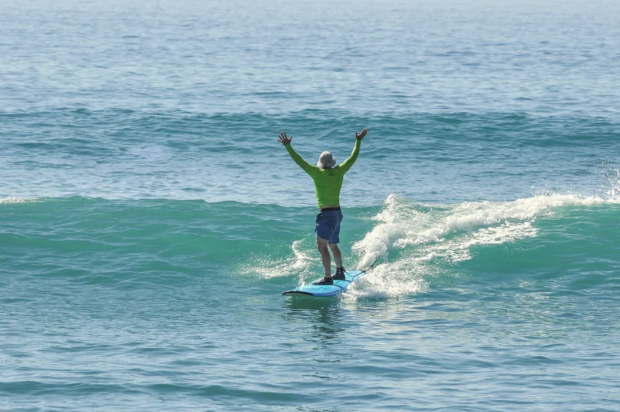 Surfer celebrating with arms up on a wave